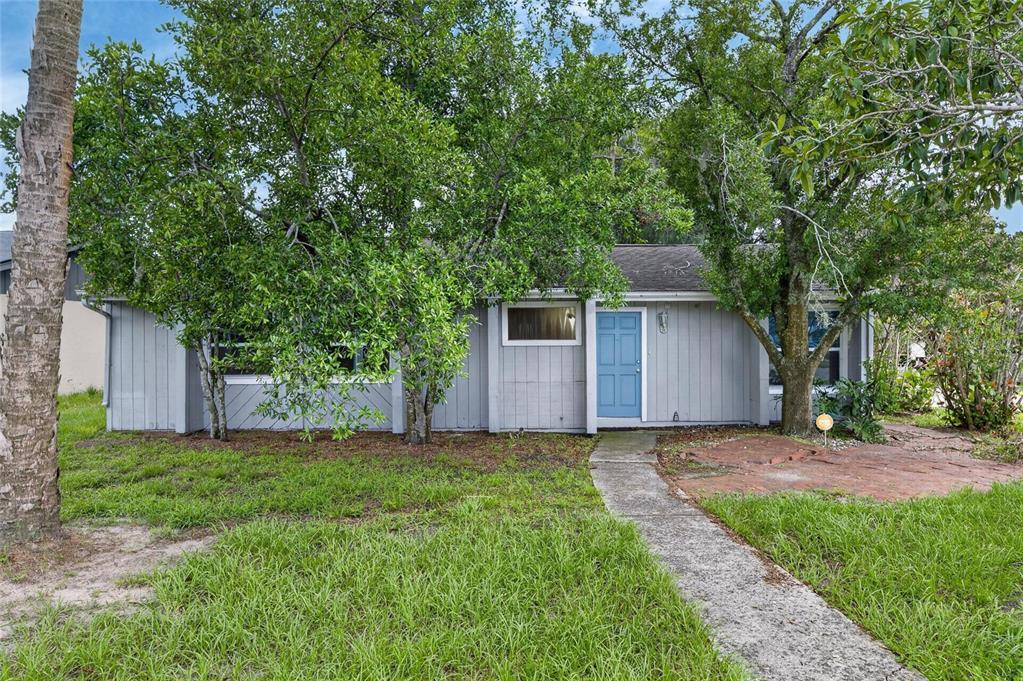 A single-story gray house with a blue front door and a concrete walkway — 5001 WHITEWAY DRIVE, TAMPA, FL