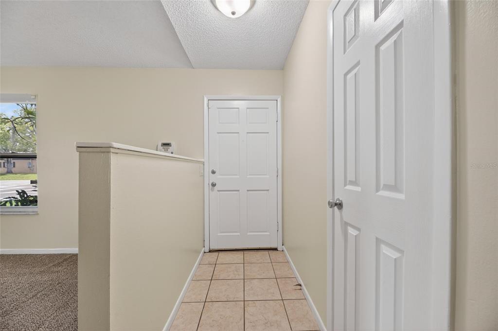 An entryway with a tiled floor, a white front door, and a half-wall partition — 5001 WHITEWAY DRIVE, TAMPA, FL
