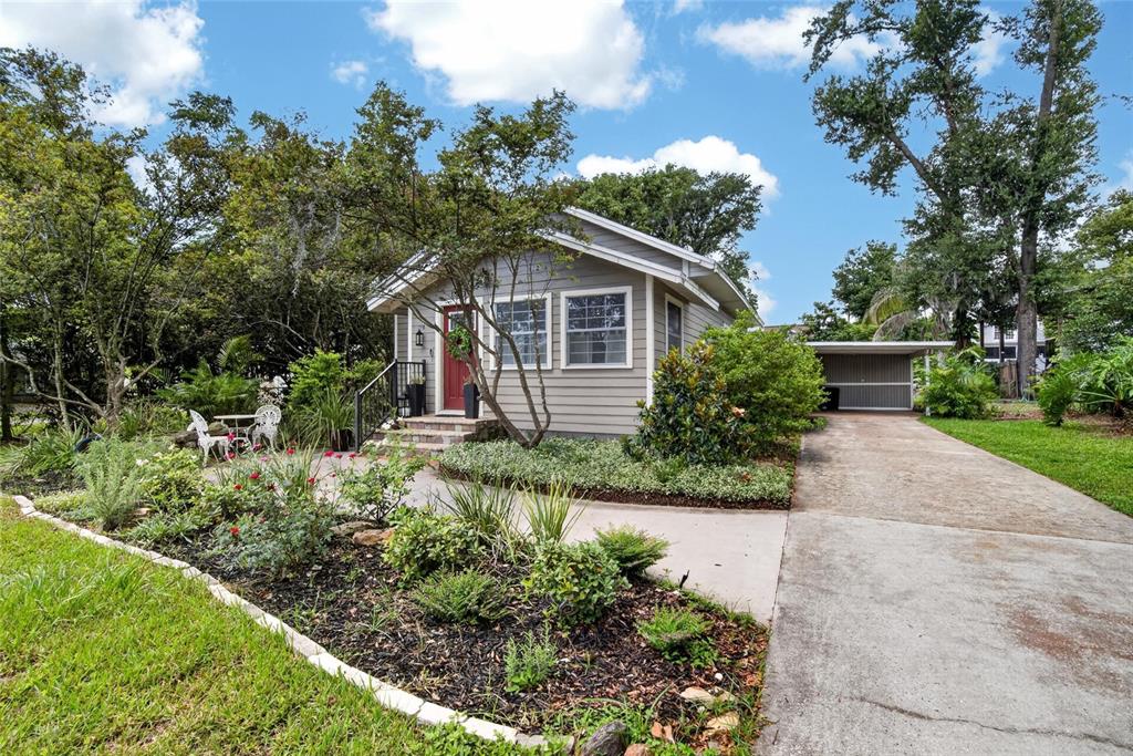 A gray house with a red front door, a concrete driveway, and a carport — 13941 13TH STREET, DADE CITY, FL