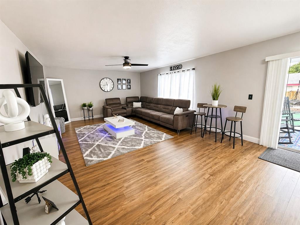 A living room features a sectional sofa, a coffee table, and a small dining area — 3483 CHARMWOOD AVENUE, SPRING HILL, FL