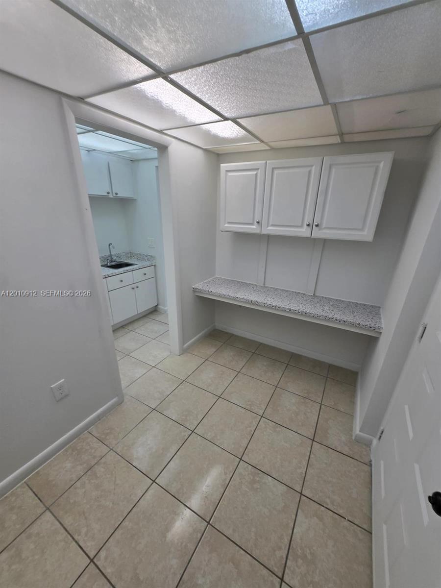 This utility room features a built-in desk, wall cabinets, and a doorway to a sink area — 6980 NW 186th St # 227A, Hialeah FL 33015, HIALEAH, FL