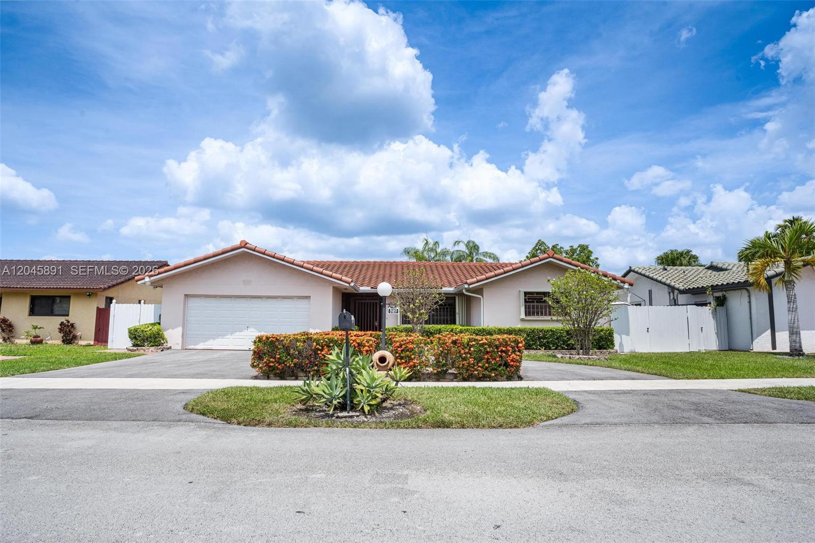 A single-story house features a tiled roof, a two-car garage, and a landscaped front yard — 520 NW 132nd Ct, Miami FL 33182, MIAMI, FL