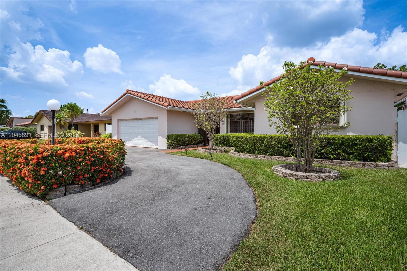 A single-story house with a tiled roof, a paved driveway, and manicured landscaping — 520 NW 132nd Ct, Miami FL 33182, MIAMI, FL