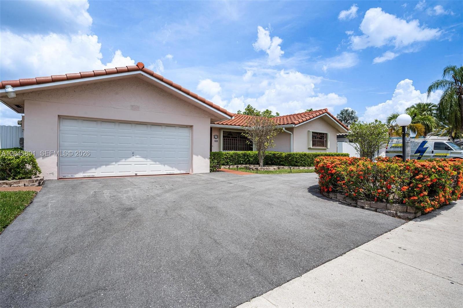 A single-story house with a white garage door, terracotta roof, and a paved driveway — 520 NW 132nd Ct, Miami FL 33182, MIAMI, FL
