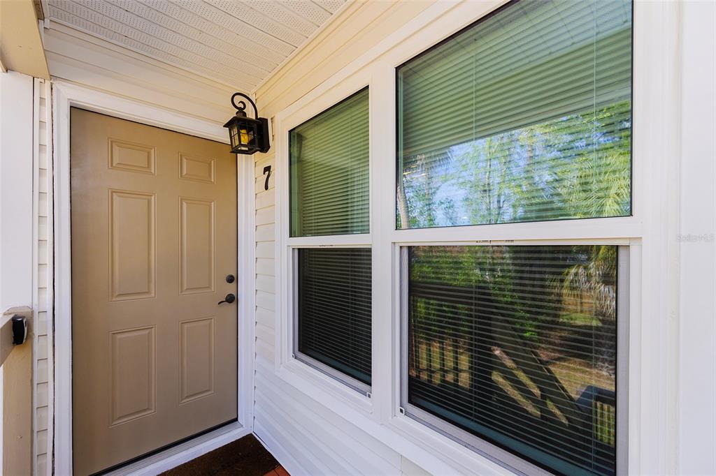 A tan front door with a number seven sign and a window on a porch — 1600 BIG TREE ROAD UNIT U7, SOUTH DAYTONA, FL