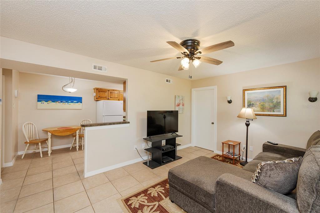 A living room with tile flooring, a ceiling fan, and an adjacent dining area — 1600 BIG TREE ROAD UNIT U7, SOUTH DAYTONA, FL