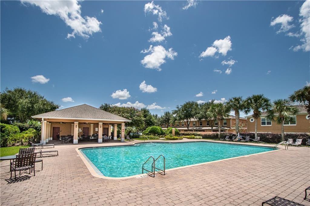 A swimming pool sits in front of a covered pavilion and multi-story residential buildings — 765 CHELSEA DRIVE, DAVENPORT, FL