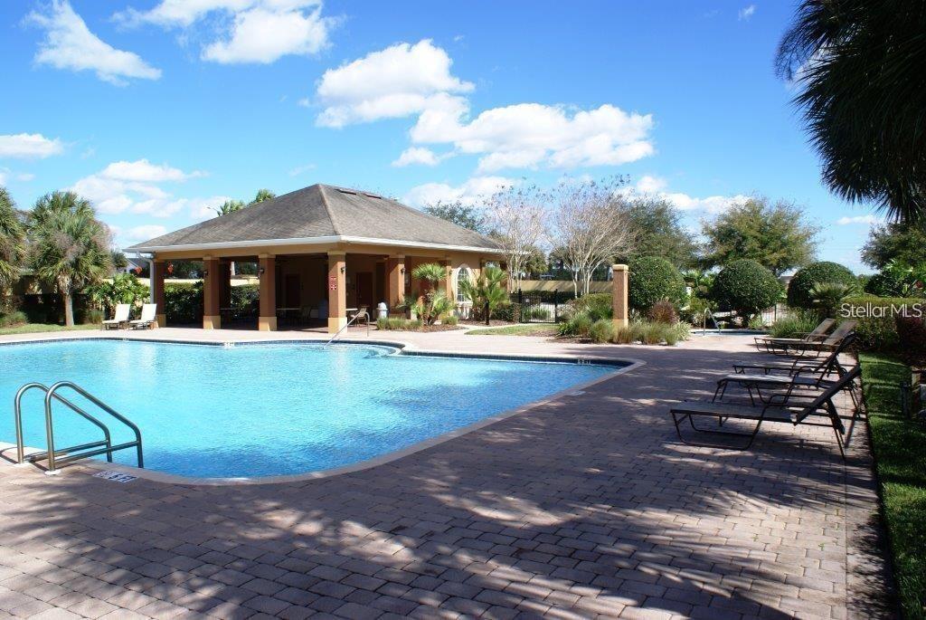 A swimming pool with a surrounding patio and a covered pavilion under a blue sky — 765 CHELSEA DRIVE, DAVENPORT, FL