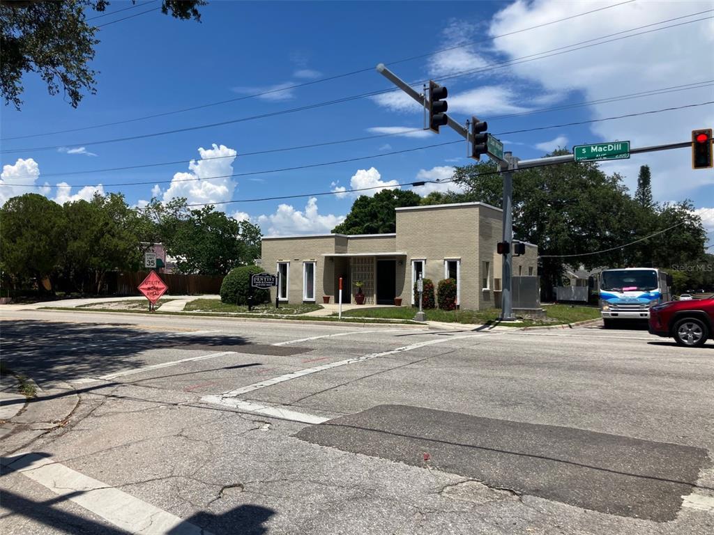 A single-story brick commercial building sits on a corner lot at a street intersection — 2210 S MACDILL AVENUE, TAMPA, FL