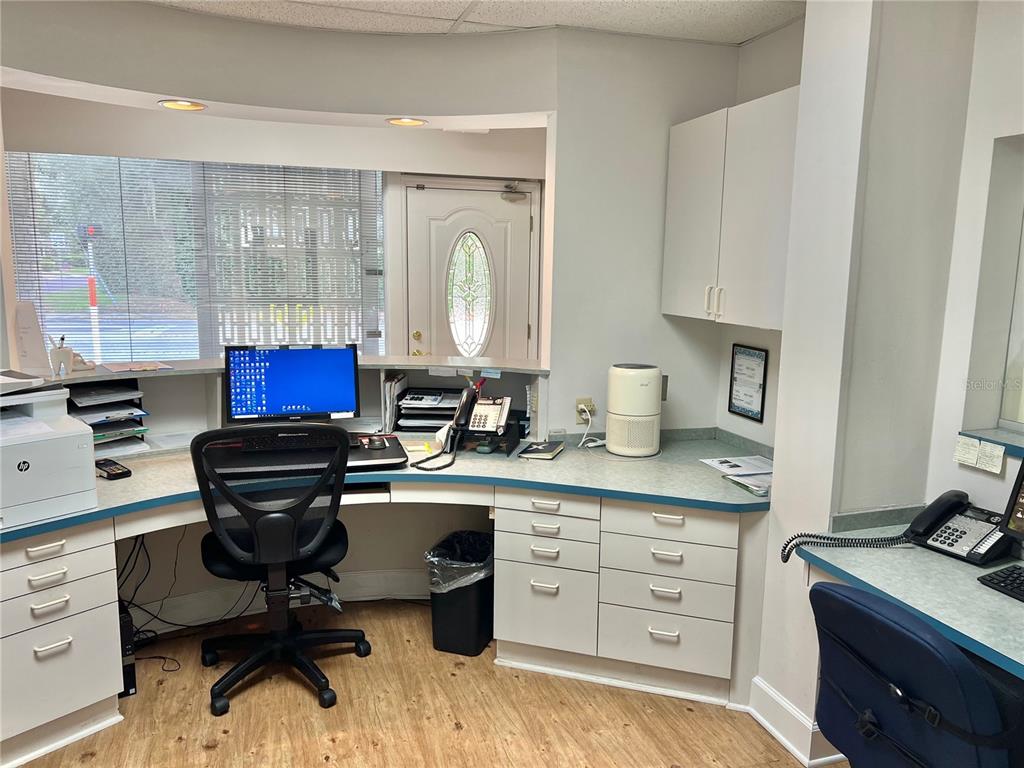 A reception area features a curved desk, a computer, office chairs, and white cabinetry — 2210 S MACDILL AVENUE, TAMPA, FL