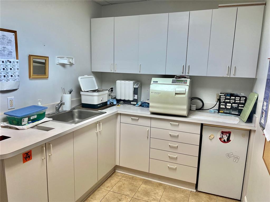 A dental sterilization room features white cabinetry, a stainless steel sink, and an autoclave machine — 2210 S MACDILL AVENUE, TAMPA, FL