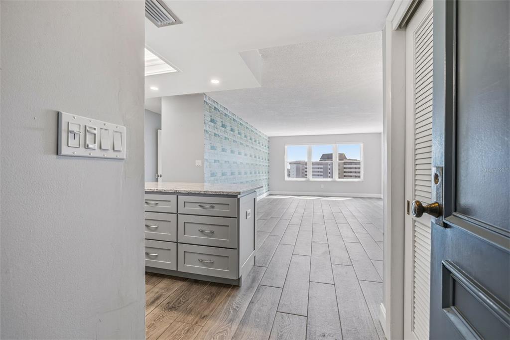 A view from a doorway into a room with gray tile floors and a kitchen island — 5220 BRITTANY DR S UNIT 901, ST PETERSBURG, FL