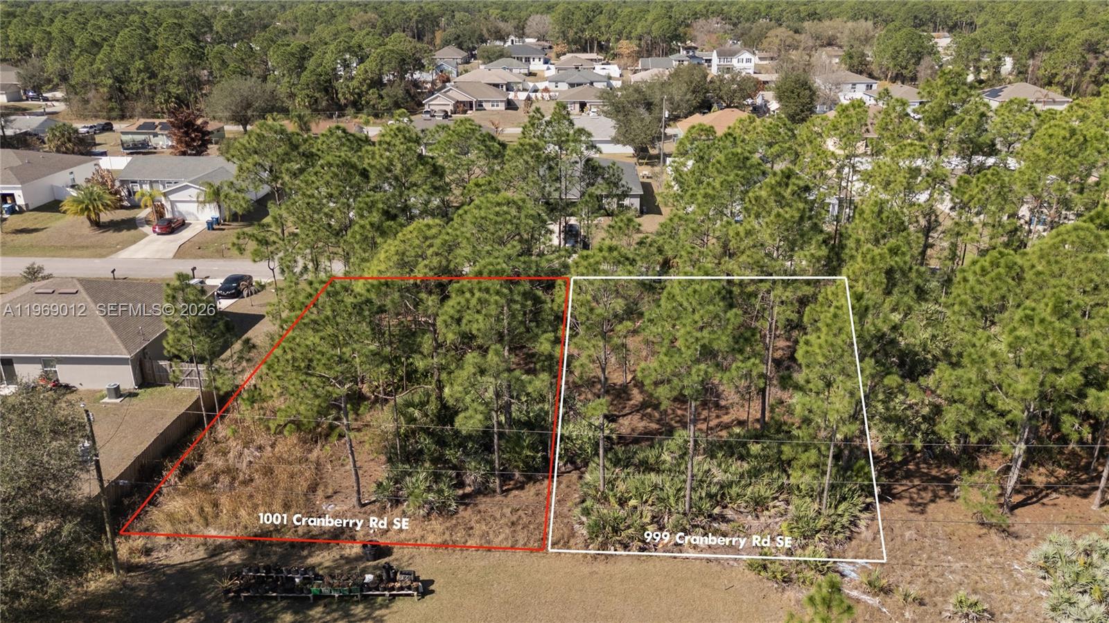 An aerial view shows two adjacent, wooded, undeveloped residential lots marked with property lines — 999 Cranberry Rd SE, Palm Bay FL 32909, PALM BAY, FL