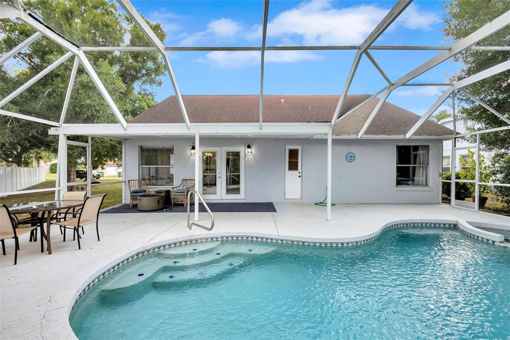 A screened-in patio features a swimming pool with steps and outdoor dining furniture — 4909 6TH AVENUE E, BRADENTON, FL