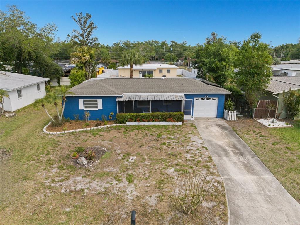 An aerial view of a blue single-story house with a screened porch and concrete driveway — 2027 E VALENCIA WAY E, CLEARWATER, FL