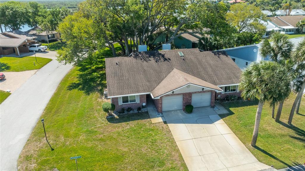 An aerial view shows a single-story brick house with a two-car garage and driveway — 1402 PORTOBELLO DRIVE, PORT ORANGE, FL