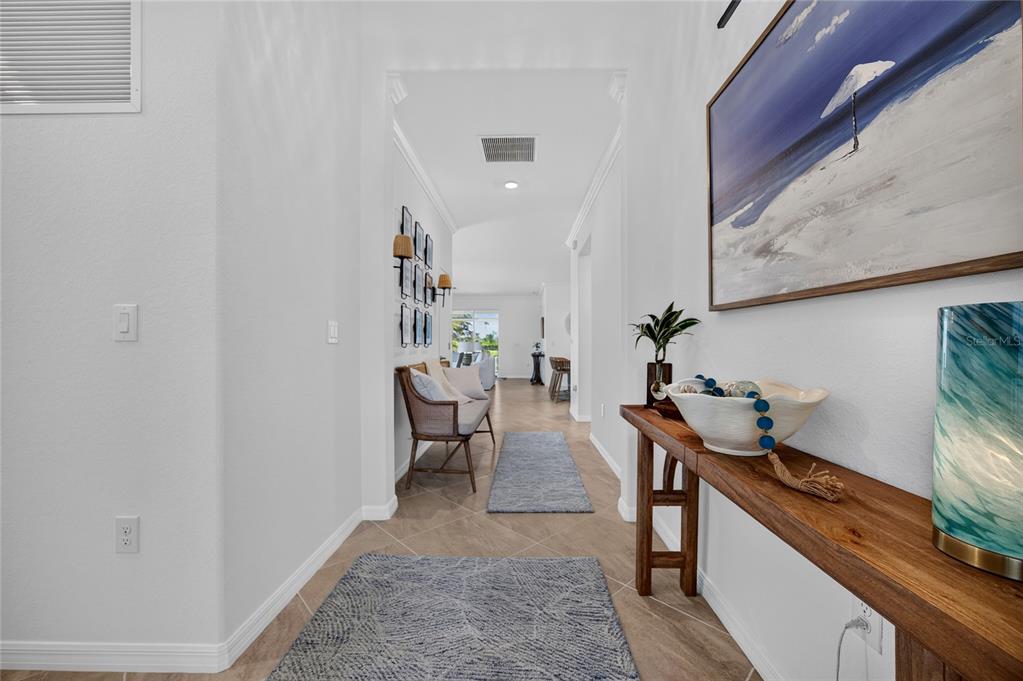 A bright hallway features tile flooring, a wooden console table, and a small seating area — 14605 PONCE DE LEON TRAIL, PORT CHARLOTTE, FL