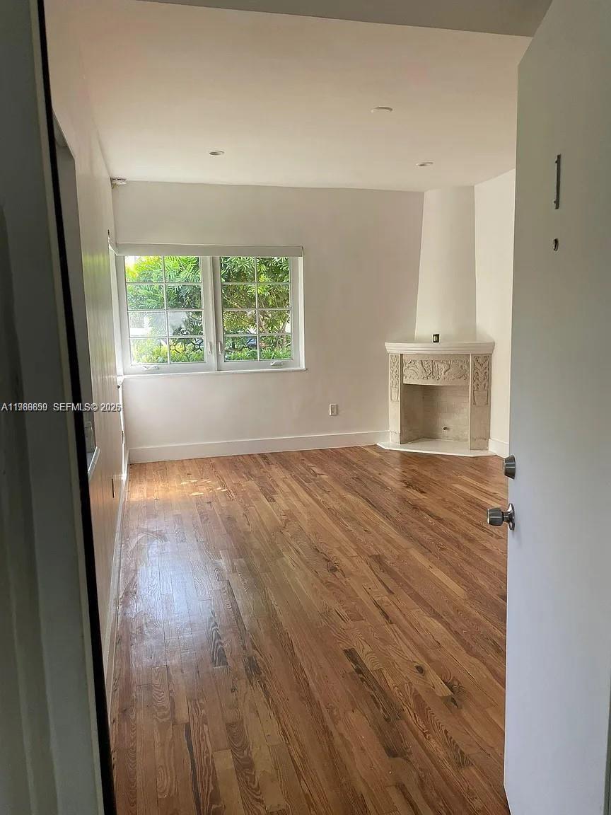 A room with hardwood floors, a window, and a corner fireplace — 727 14th Pl # 1, Miami Beach FL 33139, MIAMI BEACH, FL