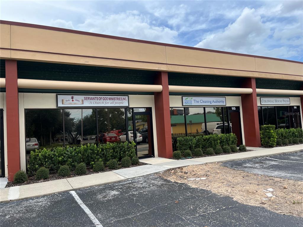 The exterior of a commercial strip mall building features three storefronts with glass doors — 1706 E SEMORAN BOULEVARD UNIT 116, APOPKA, FL