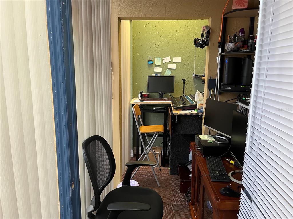 A small office nook features a desk, computer equipment, and a chair against a green wall — 1706 E SEMORAN BOULEVARD UNIT 116, APOPKA, FL