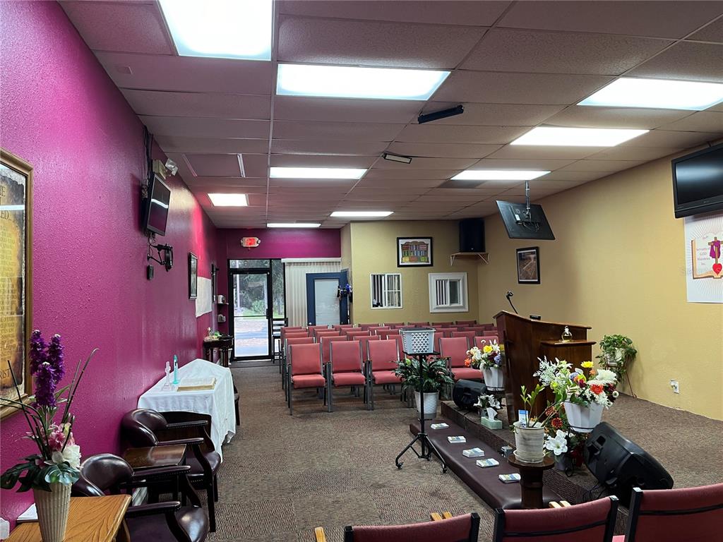 A small church sanctuary features rows of chairs, a wooden pulpit, and purple walls — 1706 E SEMORAN BOULEVARD UNIT 116, APOPKA, FL