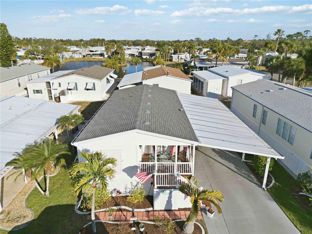 An aerial view shows a manufactured home with a shingled roof and attached carport — 10303 BURNT STORE ROAD UNIT 97, PUNTA GORDA, FL