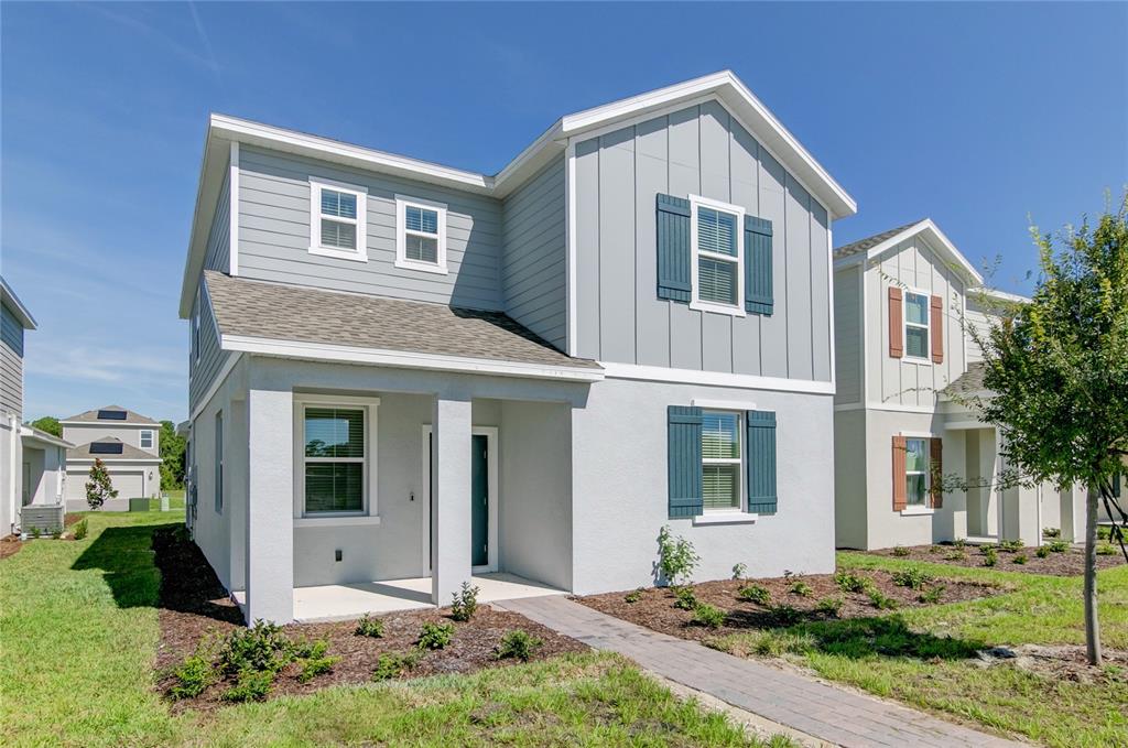 A two-story house with light gray siding, blue shutters, and a covered front porch — 6346 LIMBERPINE ALLEY, ST CLOUD, FL
