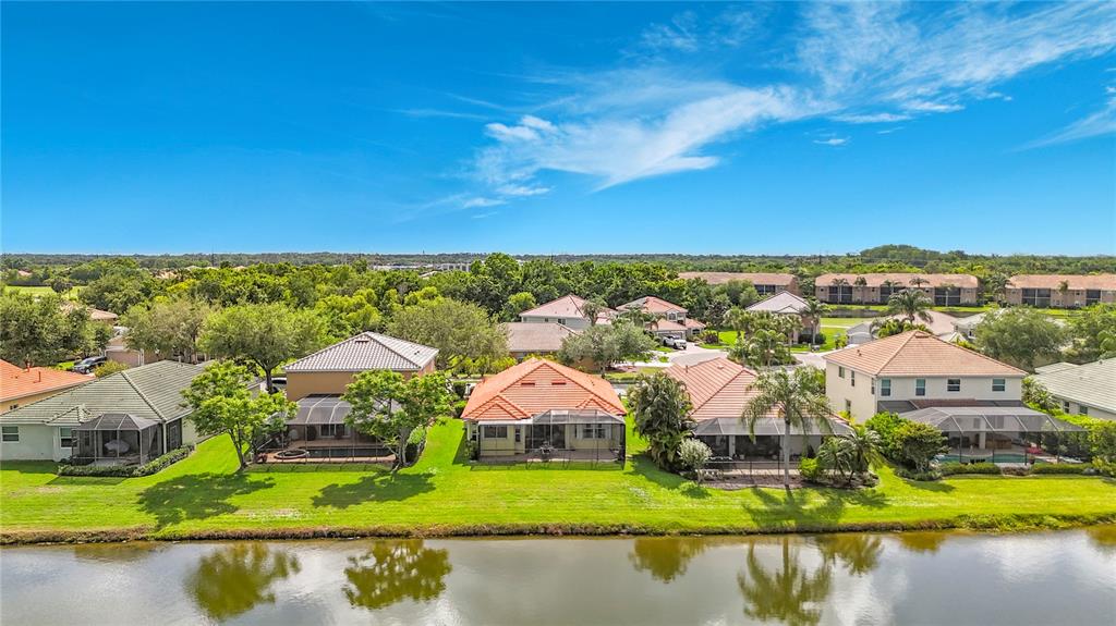 An aerial view of several suburban houses with tiled roofs situated along a lake — 8721 STONE HARBOUR LOOP, BRADENTON, FL