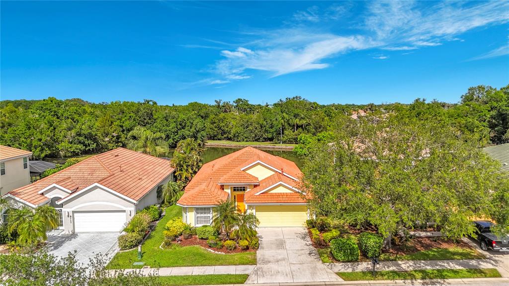 An aerial view shows two suburban houses with orange tile roofs and concrete driveways — 8721 STONE HARBOUR LOOP, BRADENTON, FL