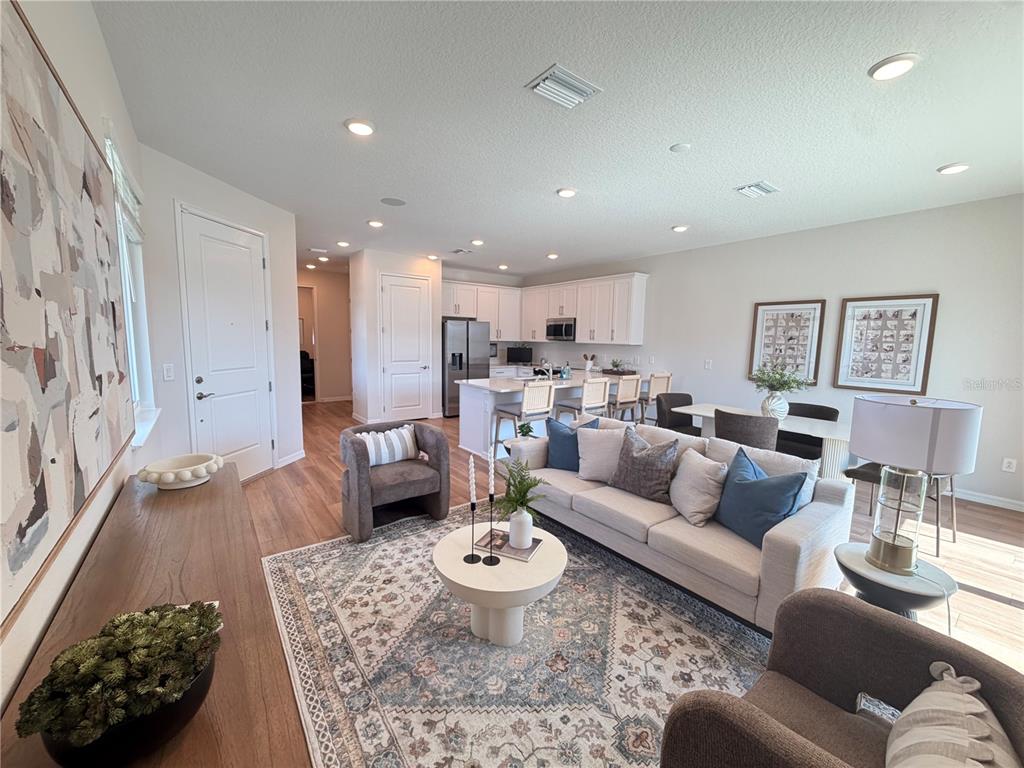 A carpeted staircase with a wooden handrail leads to a living area with wood flooring — 5839 ANGELA LEYLA PLACE, RIVERVIEW, FL