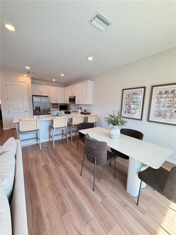 A modern kitchen features white cabinets, stainless steel appliances, and a quartz countertop island — 5839 ANGELA LEYLA PLACE, RIVERVIEW, FL