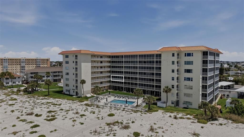 An exterior view of a multi-story beachfront condominium building with a swimming pool — 1150 TARPON CENTER DRIVE UNIT 304, VENICE, FL