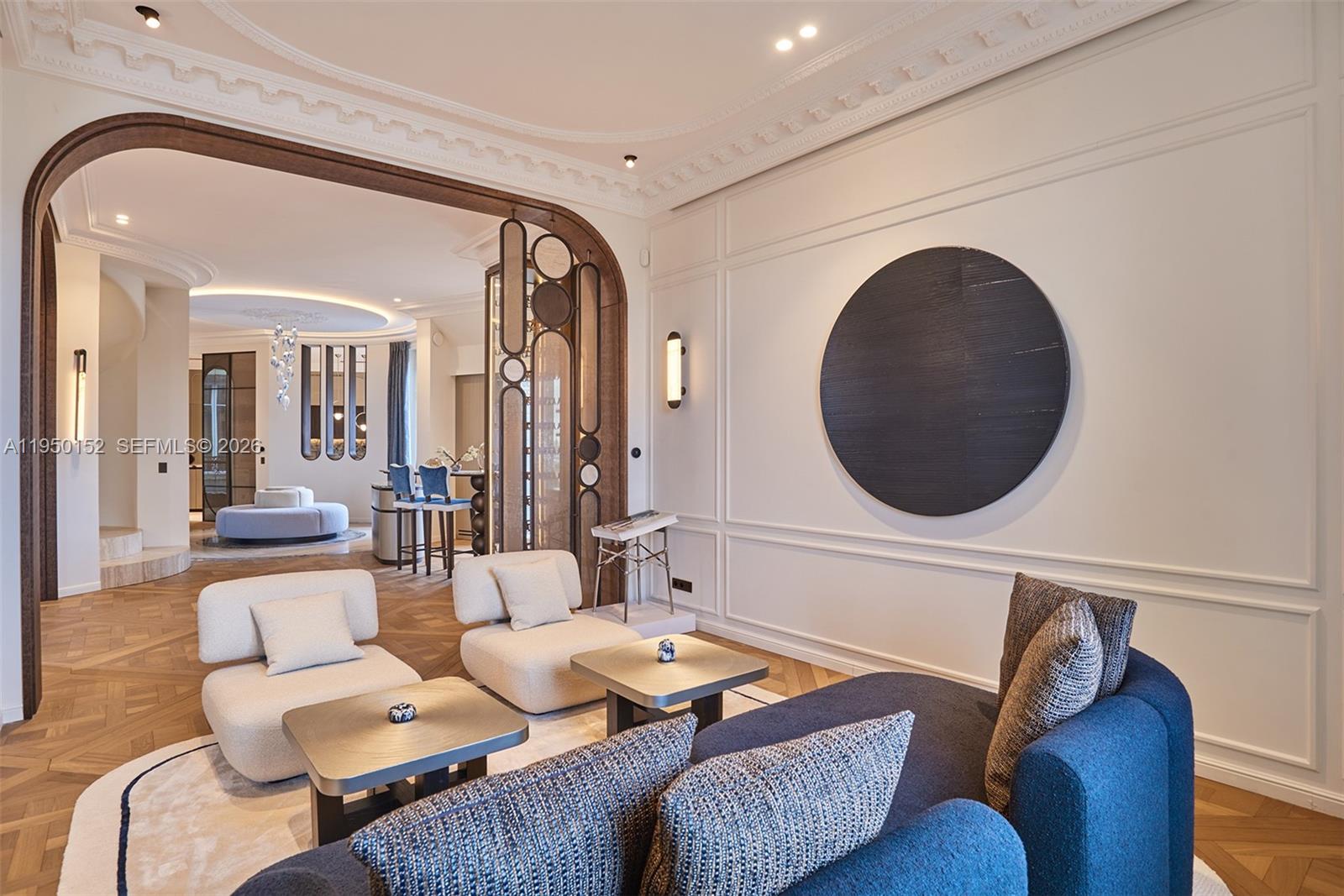 A living room features a blue sofa, two cream chairs, and a large circular wall art — 48 AVENUE GEORGES MANDEL, FR, FR