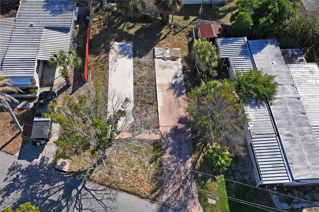 An aerial view shows a vacant lot with two concrete pads between two mobile homes — 736 DRIFTWOOD LANE, TARPON SPRINGS, FL