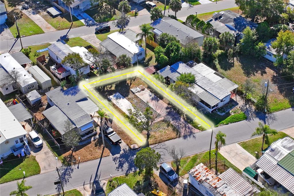 An aerial view shows a vacant rectangular lot highlighted in yellow between two residential buildings — 736 DRIFTWOOD LANE, TARPON SPRINGS, FL