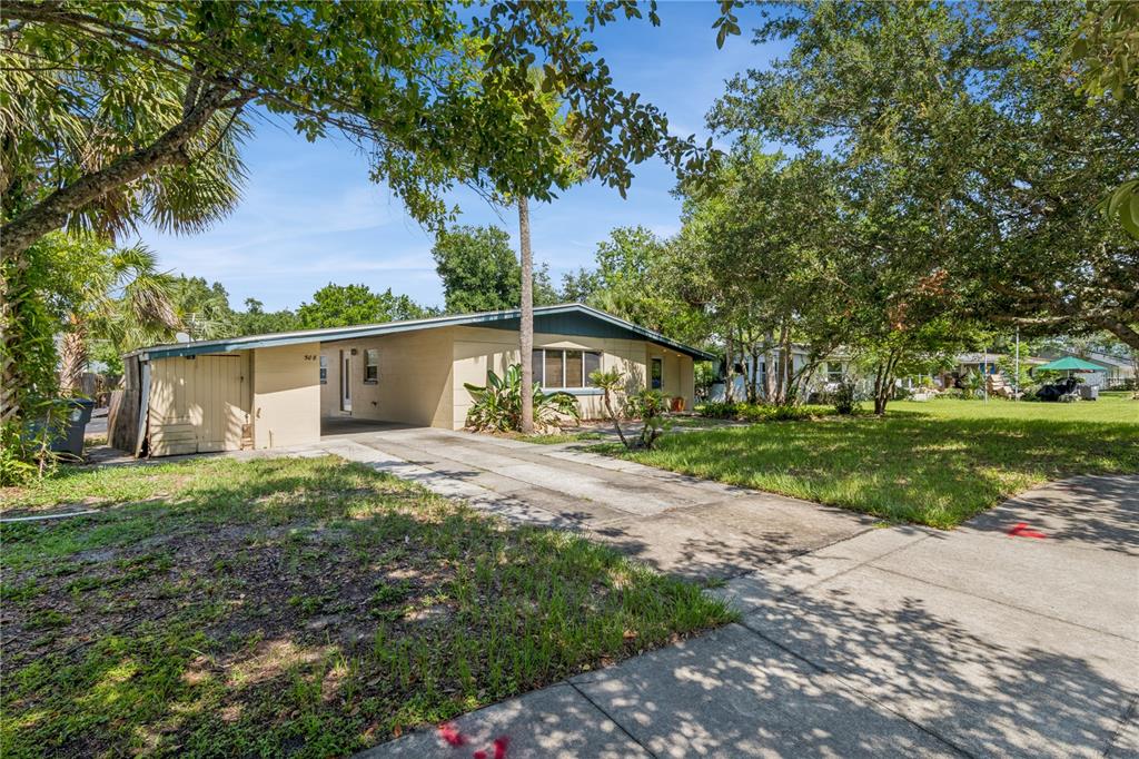 A single-story house with a carport and a concrete driveway sits on a grassy lot — 508 DUNBLANE DRIVE, WINTER PARK, FL