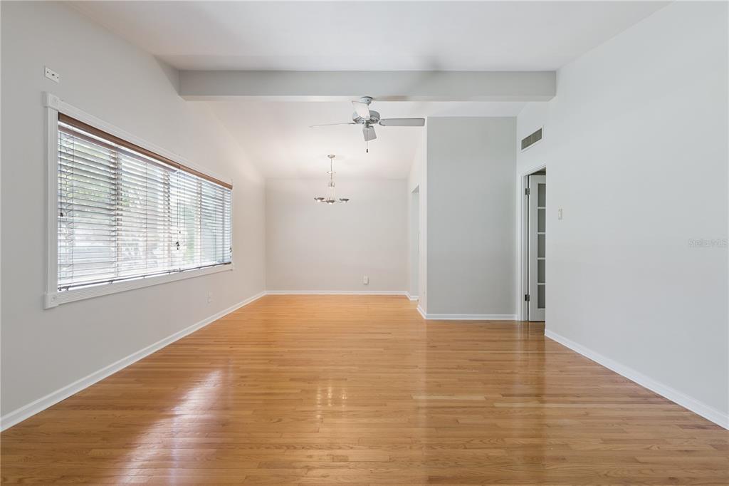 An empty room with hardwood floors, a ceiling fan, and a large window with blinds — 508 DUNBLANE DRIVE, WINTER PARK, FL