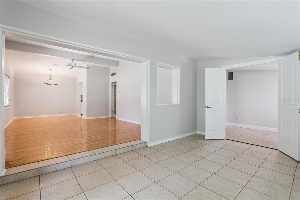 A room with tile flooring leads to a sunken living area with hardwood floors — 508 DUNBLANE DRIVE, WINTER PARK, FL