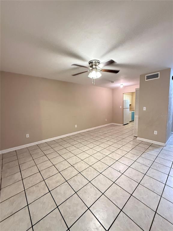 A room with beige walls, a ceiling fan, and light-colored square floor tiles — 1721 SW 68TH TERRACE UNIT 1721, GAINESVILLE, FL