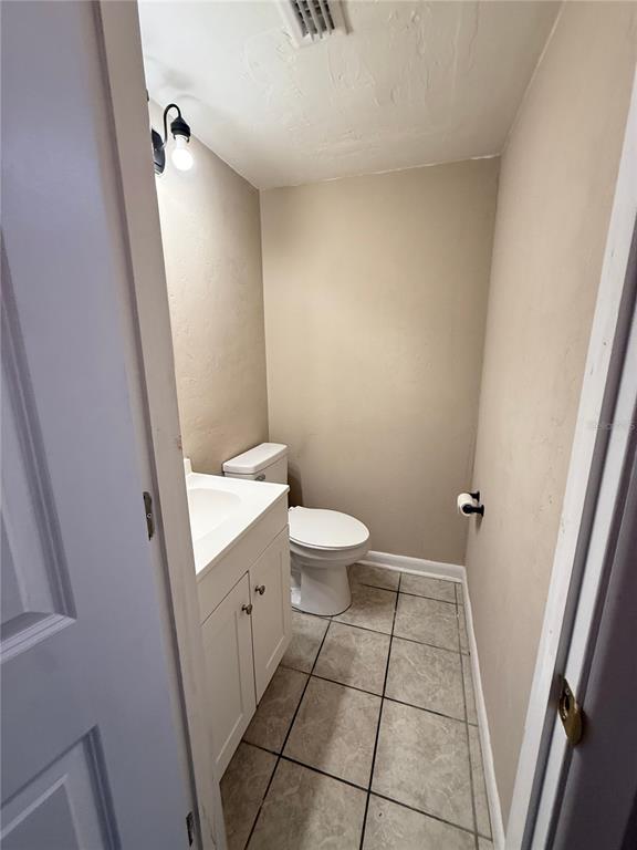 A small bathroom features a white vanity, a toilet, and light-colored tile flooring — 1721 SW 68TH TERRACE UNIT 1721, GAINESVILLE, FL