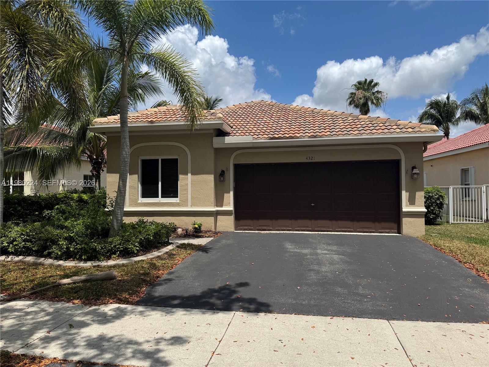 A single-story house with a brown garage door, tiled roof, and a palm tree — 4321 Willow Ridge Dr, Weston FL 33331, WESTON, FL