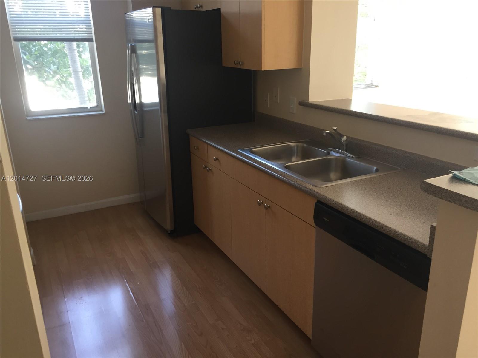 An empty bedroom features gray walls, beige carpeting, a window with blinds, and a ceiling light — 1900 Van Buren St # 214B, Hollywood FL 33020, HOLLYWOOD, FL