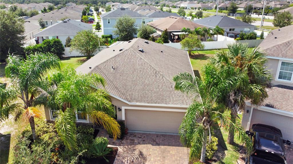An aerial view shows a suburban house with a shingled roof, garage, and palm trees — 1800 STILLWOOD WAY, ST CLOUD, FL