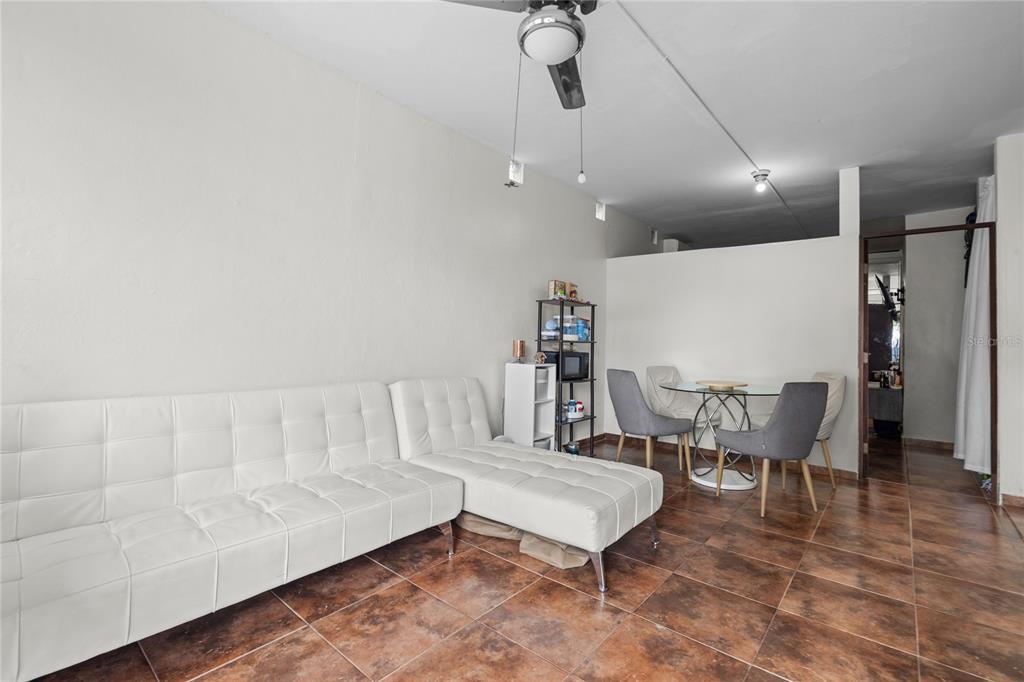 A living and dining area features white tufted furniture, a glass table, and tiled floors — 228 CALLE 25, GUAYNABO, PR