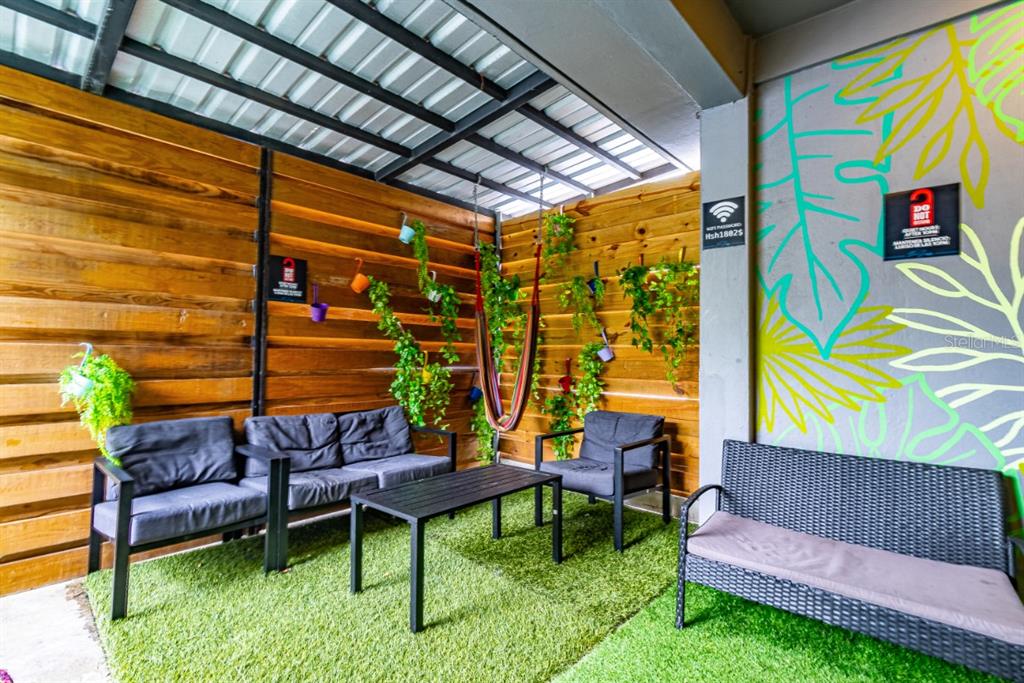 An outdoor patio features artificial turf, wooden walls, a hammock, and various seating arrangements — 1802 AVE FERNANDEZ JUNCOS, SAN JUAN, PR