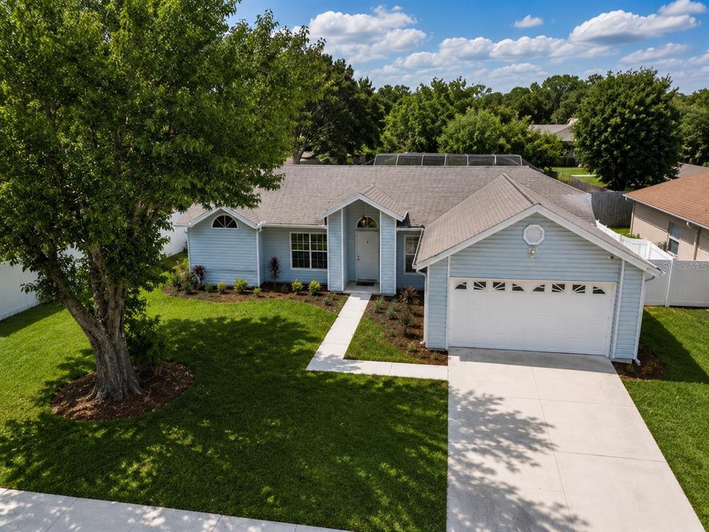 An elevated view of a light blue single-story house with a white garage and lawn — 5113 TIMBER RIDGE TR, OCOEE, FL