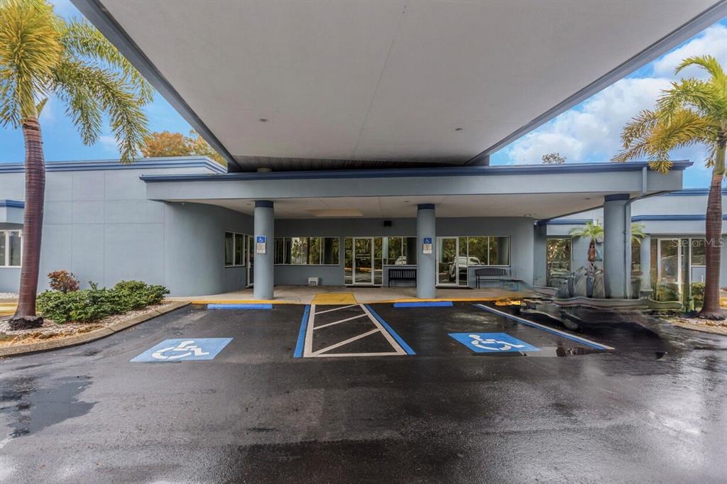 The exterior of a building features a covered entrance with two designated handicap parking spaces — 7641 66TH STREET N, PINELLAS PARK, FL