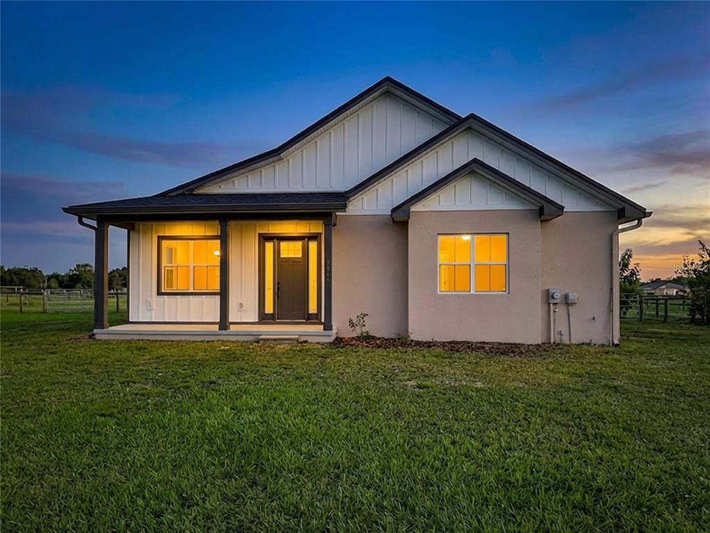 A single-story house with a covered porch, white vertical siding, and a tan stucco exterior — 3063 ENGLISH ROAD, PLANT CITY, FL