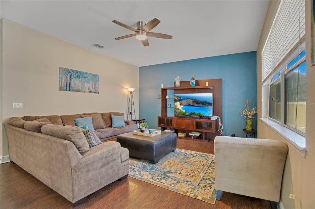 A living room features a sectional sofa, a large ottoman, and a wooden media console — 2053 NOBSCOT PLACE, APOPKA, FL