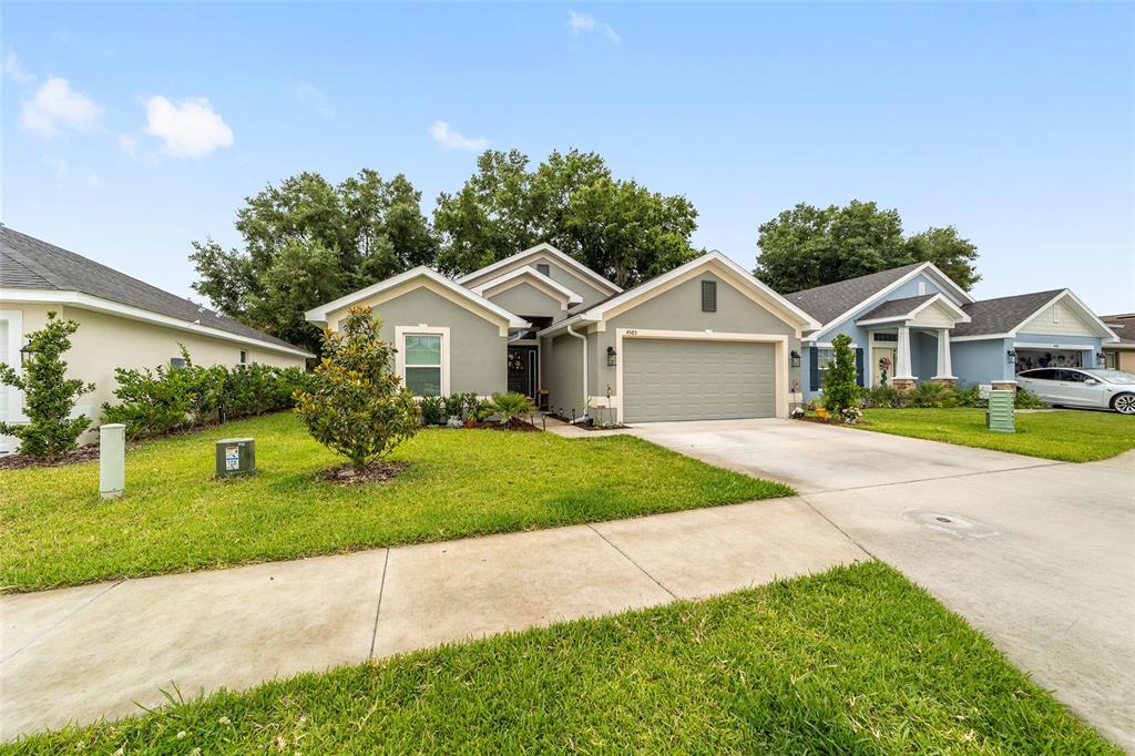 A single-story house with a green exterior, a two-car garage, and a front lawn — 4585 SE 25TH LOOP, OCALA, FL